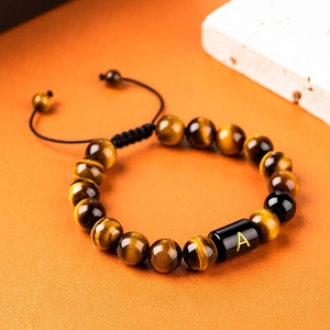 Handmade 10mm tiger eye stone beaded bracelet with golden letter A on orange background