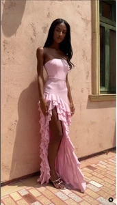 Détail de la robe de soirée rose sans bretelles avec bords à volants et fente latérale