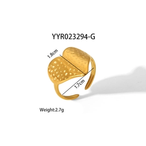 Detail of a golden hammered texture ring with irregular double-arched design