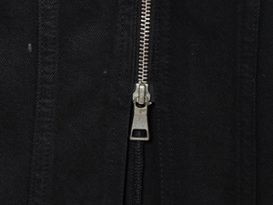 Close-up of the silver metal zipper detail on the back of this black denim dress
