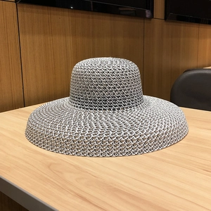 Gros plan détaillé d'un chapeau de paille à larges bords avec texture tissée bicolore