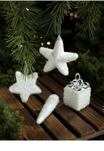 Macro detail of white glitter Christmas ornaments with silver ribbons on a wood tray