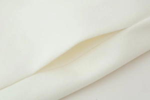 Detailed macro view of high-quality white wool coat fabric and pocket stitching