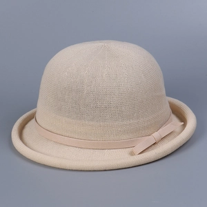 Close-up of the beige knit bowler hat featuring a delicate bow tie and woven texture