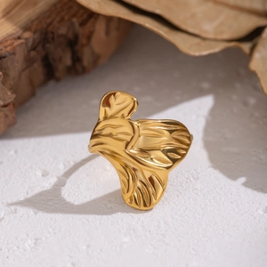 Elegant gold ginkgo leaf ring featuring fine leaf vein texture on a natural wooden display