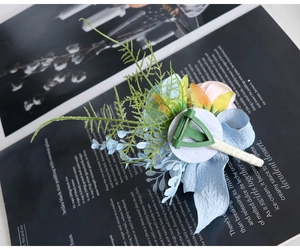 Detail of blue and pink wedding boutonniere showing the secure T-pin and silk ribbon finish