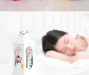 Close-up of white Christmas lantern with snowman scene and metal ring handle for desktop