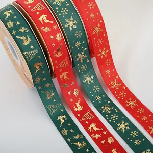 Detailed close-up of Christmas ribbon rolls with gold foil reindeer and snowflake patterns