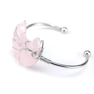 Detalle macro del cristal rosa en forma de luna envuelto en hilo de plata en brazalete