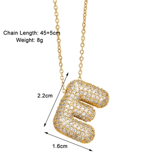 Macro detail of gold letter E pendant with white zircon pavé and size dimensions