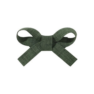 Detailed texture of dark green linen fabric bow hair clip on white background