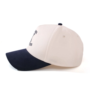 Side view of cream cotton baseball cap with navy blue brim and vintage letter embroidery