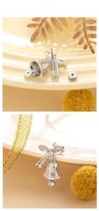 Detailed view of silver bow bell earrings with star cutouts and a clear zircon drop