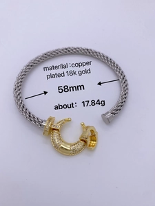 Detail of 18K gold plated braided bracelet with silver and gold tones and zircon inlay