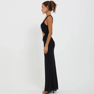 Dettaglio laterale di un abito lungo nero aderente con taglio alla moda sulla vita