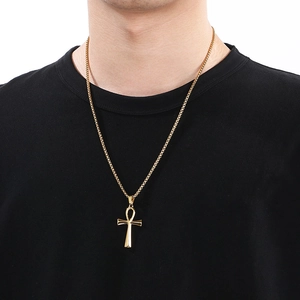 Male model wearing gold Ankh cross pendant necklace with box chain over black shirt