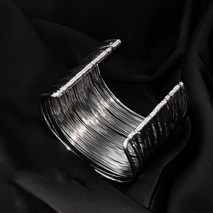 Macro shot of silver multi-layer wire wrapped open cuff bracelet on black velvet fabric