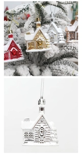 Close-up of hanging glitter snowy house ornaments on a Christmas tree branch