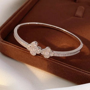 Macro detail of silver clover bangle with shimmering pave-set stones in a jewelry box