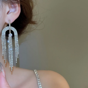 Gros plan de boucles d'oreilles pendantes argentées avec strass sur un mannequin