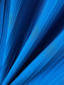Macro detail of blue pleated linen fabric texture on men's striped casual Henley shirt