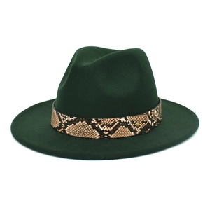 Détail d'un chapeau fedora vert foncé avec bande en cuir serpent et rivet doré chic