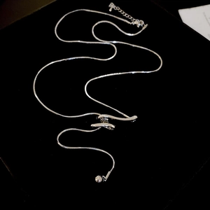 Macro detail of silver twisted knot necklace with fringe tassel and small ball pendant