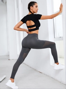 Detail showing back hollow design of black pilates top and laser cut leggings set