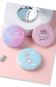 Close-up of portable round makeup mirrors with cute illustrations and typography design