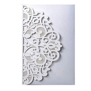 Detailed macro view of laser-cut white lace pattern on hollowed-out wedding invitation card