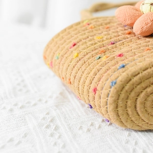 Detailansicht der khakifarbenen Baumwolltasche mit bunten Pompons und floralen Akzenten