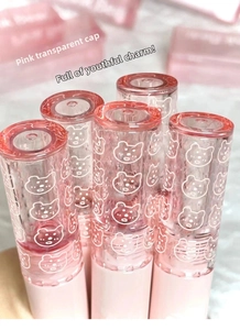 Close-up of pink lip glaze set with bear prints and translucent caps in soft lighting