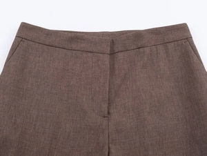 Gros plan du pantalon décontracté marron montrant la texture, les passants et la braguette