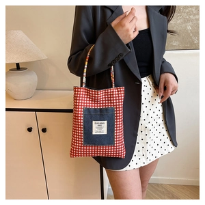 Détail du sac cabas à carreaux réversible avec poche en jean sur tissu texturé