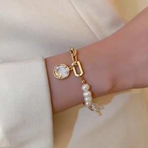 Elegant freshwater pearl bracelet with gold chain and rhinestone pendant on wrist