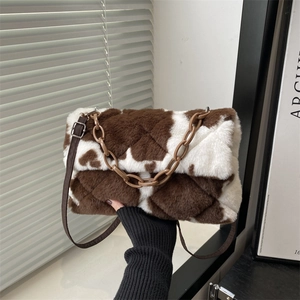 Plush cow print underarm bag with thick resin chain strap and quilted faux fur texture