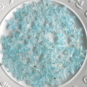Close-up of blue frosted starfish beads with gold specks for DIY jewelry making