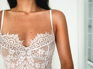 Détails en gros plan de la dentelle florale blanche sur un body sexy dos nu
