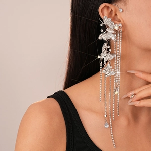 Macro shot of a silver butterfly ear cuff with sparkling zircon tassels on a female model