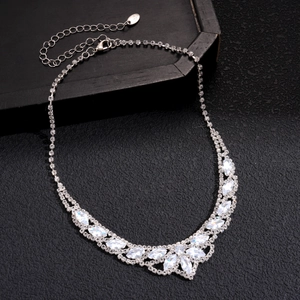 Detailed view of a silver choker necklace with teardrop rhinestones on black background