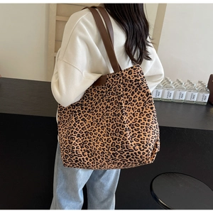Grand sac cabas en toile à motif léopard avec des anses en cuir marron porté