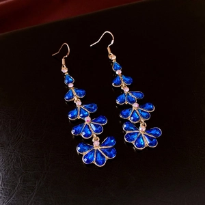 Detailed close-up of blue crystal tassel earrings with gold-toned vintage setting