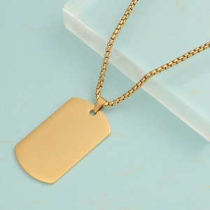 Polished gold rectangular dog tag necklace with box chain on a marble background