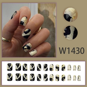 Abstract black and white leopard print press-on nails with gold foil in a 24-piece set