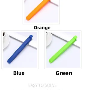 Three colorful plastic food sealing clips in orange blue and green for kitchen bags