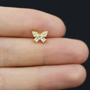 Detailed close-up of a gold butterfly nose stud with shimmering clear zircon stones
