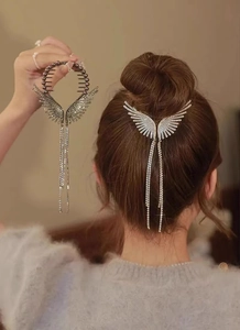 Close-up of rhinestone wing hair claw with long tassels shown on a bun hairstyle