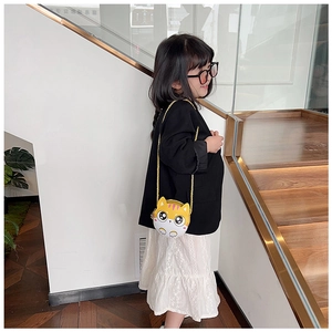 Fillette portant un petit sac bandoulière chat jaune avec une chaîne dorée