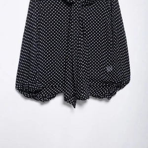 Relaxed fit black polka dot cape shirt with tie-up bow and pleated hem for women