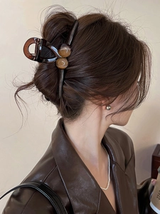 Elegant large amber resin shark hair claw clip worn by a model from a side-back view